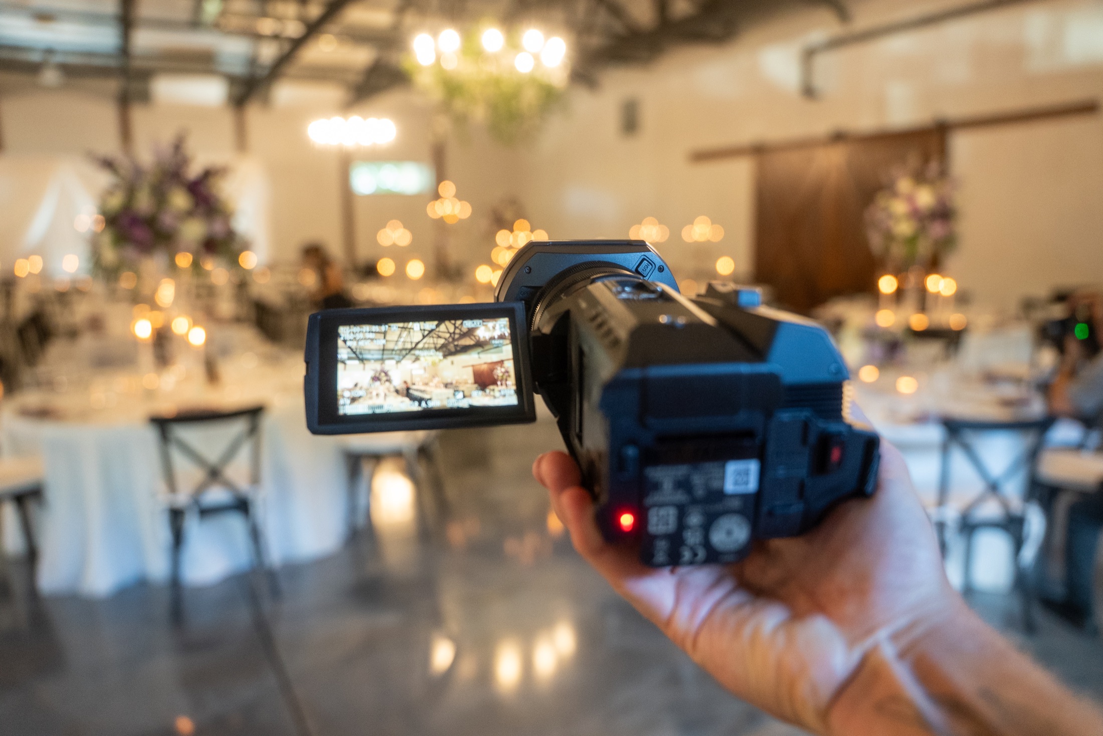 A Happily Captured camera filming inside a wedding venue