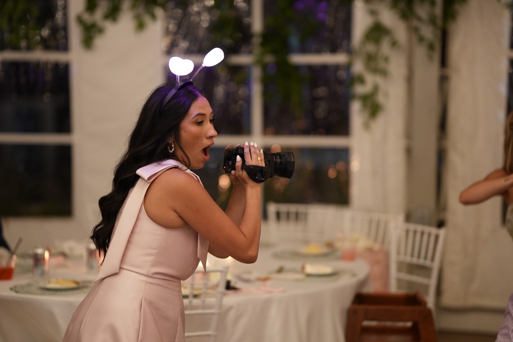 A wedding guest joyfully filming the celebration