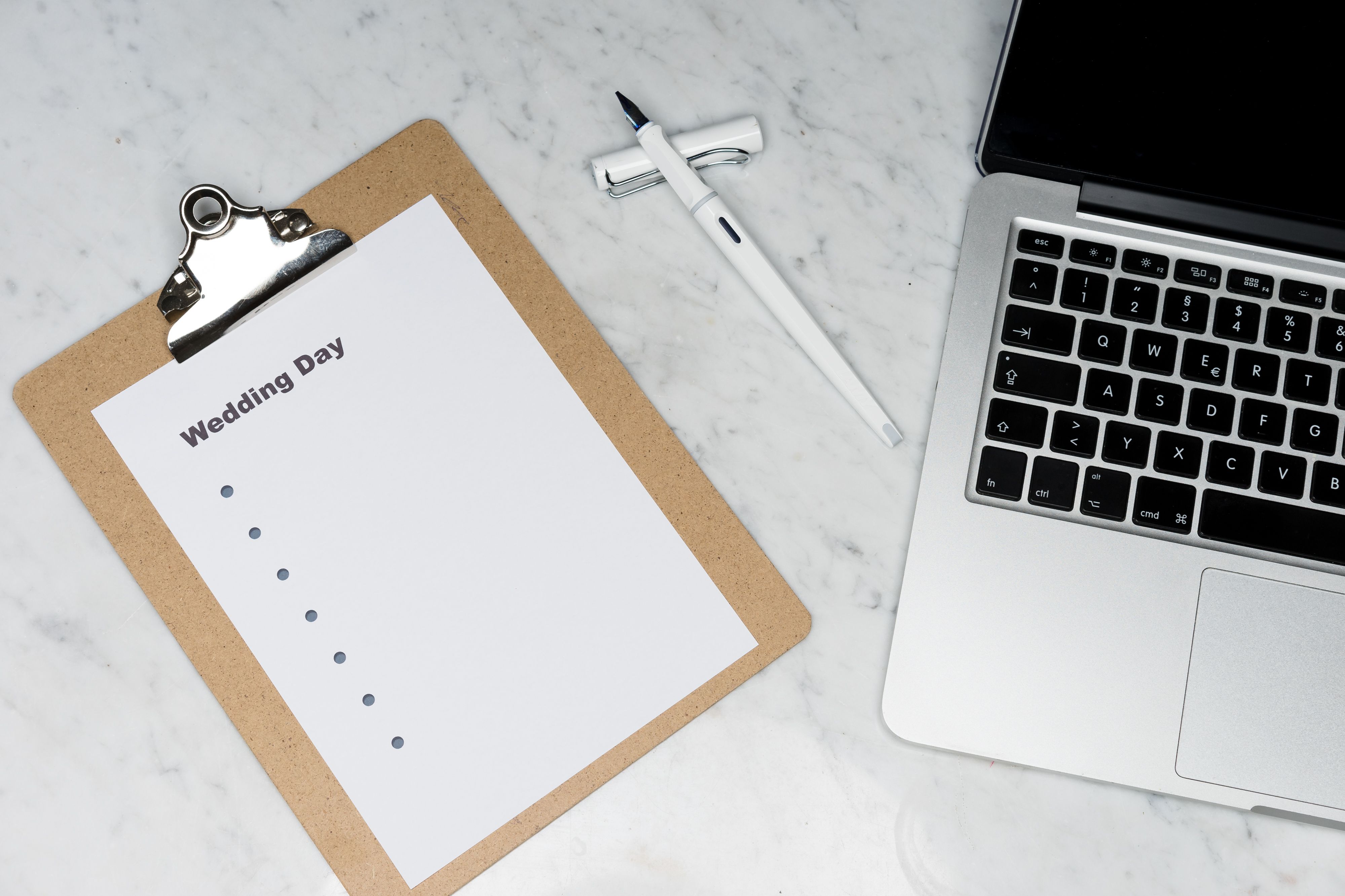 Wedding planning notes beside a laptop and coffee